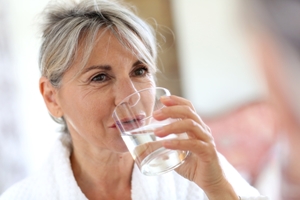 A person holding a water bottle on a hot summer day