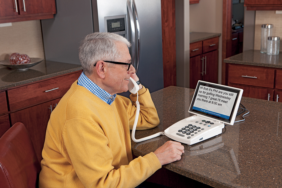 A captioned phone displaying text for a person with hearing loss. Learn more about how these phones can assist individuals with hearing impairments by reading our FAQs.