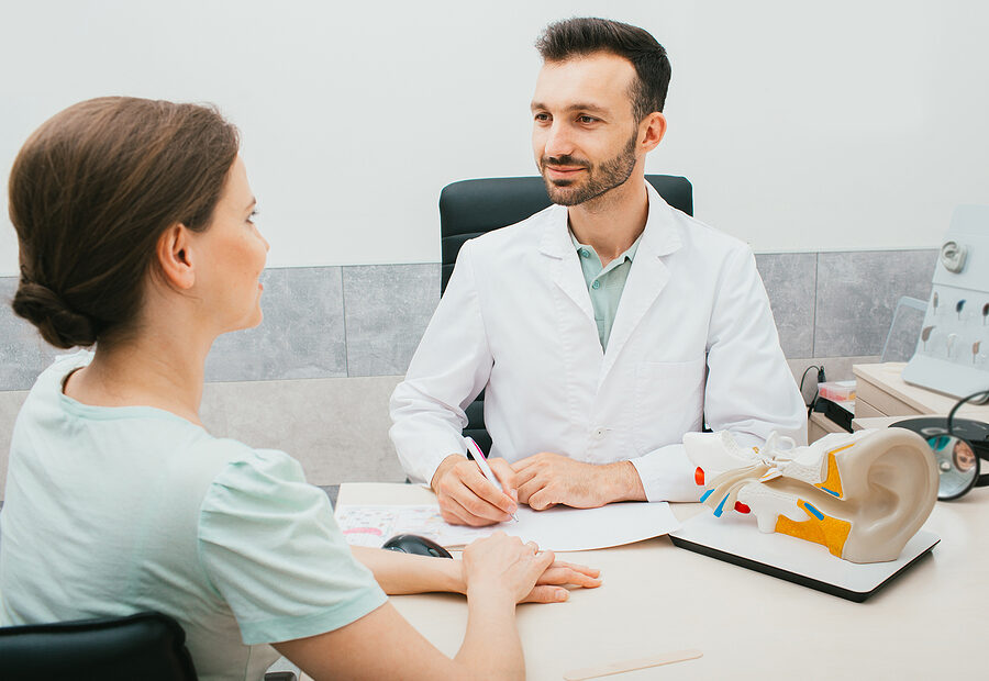 Image of a person with hearing loss using communication accommodations to aid in understanding conversations.