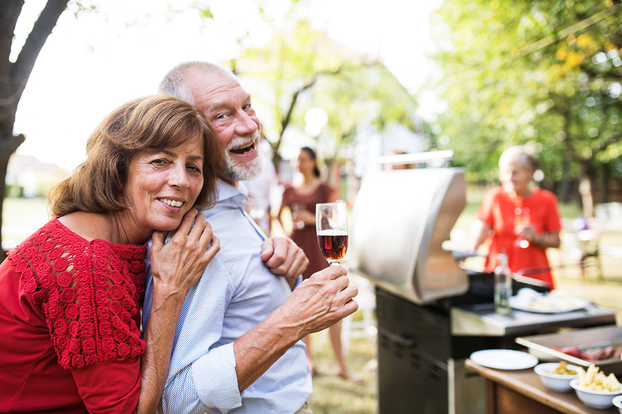 A group of friends enjoying a summer barbecue with delicious food on the grill