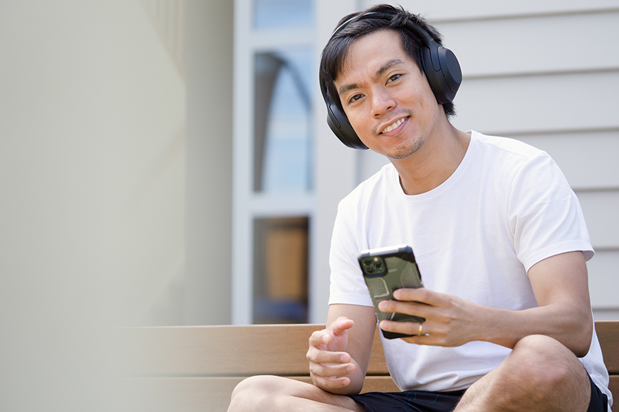 A person with hearing loss using a smartphone to access accessibility features such as closed captioning and visual alerts.