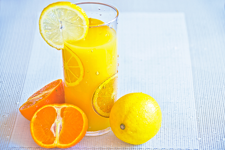 A person holding a cup of hot tea with lemon and honey