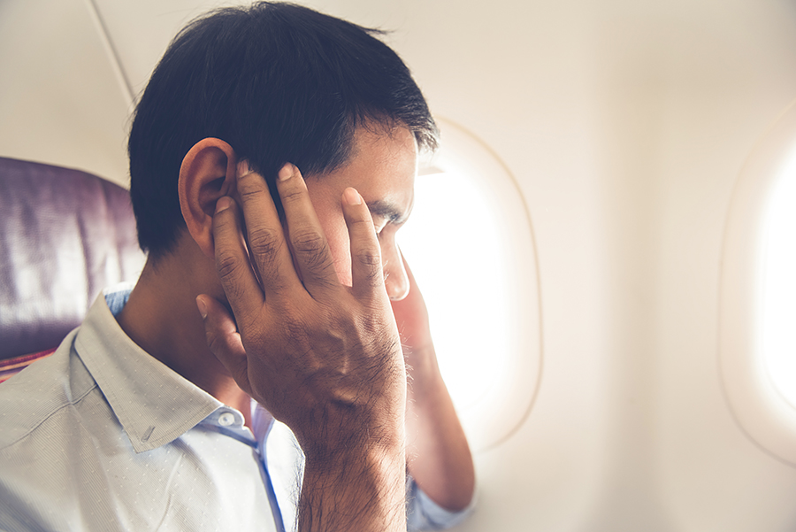 A person experiencing ear pain can find relief with these flying tips to prevent or alleviate discomfort