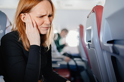 Image of a person holding their ear in pain