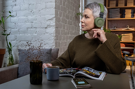 A person with hearing loss listening to a podcast on communication strategies.