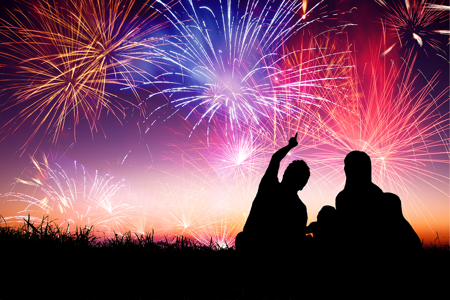 A person wearing ear protection while watching fireworks on the 4th of July to protect their hearing and practice fireworks safety.