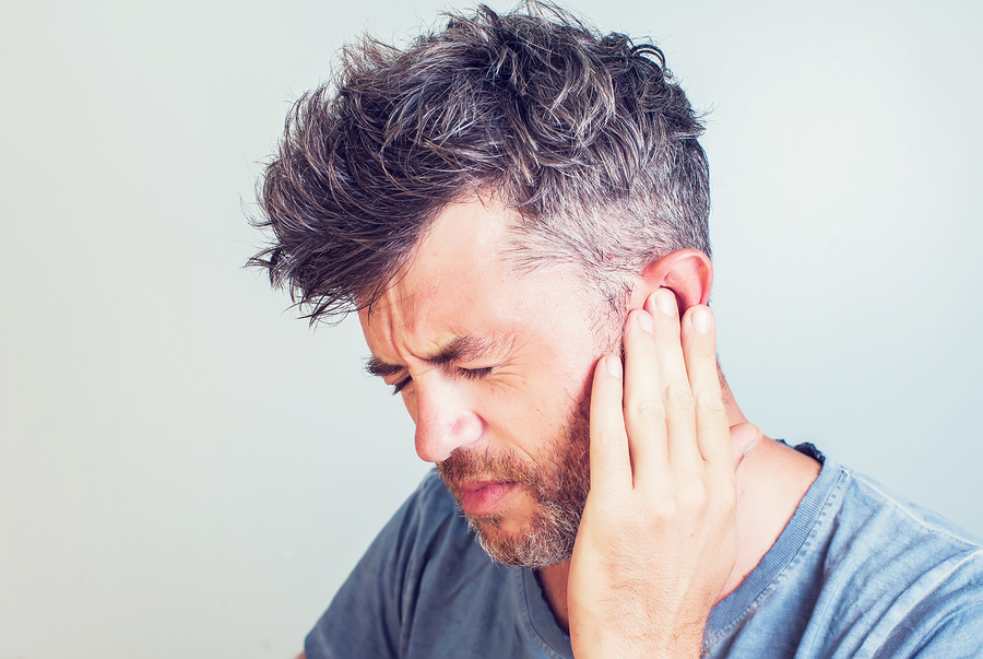 Image of a person holding a hearing aid