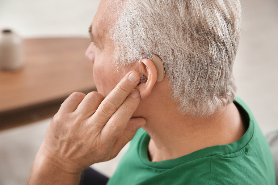 A person holding a hearing aid