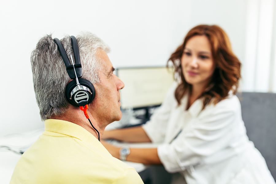 Audiologist conducting a hearing test to assess hearing loss. Visit our audiology clinic for professional services and solutions for hearing loss.