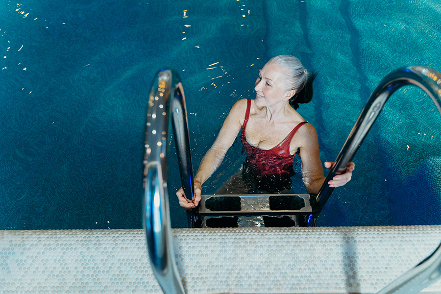 Group of people participating in fun indoor exercises like water aerobics, spin class, and yoga.